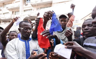 Des manifestants sénégalais brûlent un drapeau français, le 16 janvier 2015 à Dakar, pour protester contre la publication d'une caricature de Mahomet par Charlie Hebdo