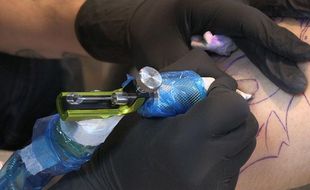Un tatoueur en pleine action au Mondial du tatouage de Paris, le 07 mars 2014.