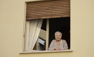 Une personne âgée regardant à la fenêtre lors du confinement, illustration