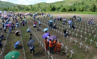 Des survivants du typhon Haiyan rendent hommage à leurs proches victimes de la catastrophe naturelle, près de la ville philippine de Tacloban, le 8 novembre 2014