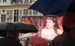 Pas découragées par la pluie, des fans d'opéra regardent, le 24 mars 2008 sur un écran géant disposé sur la façade de l'Hôtel de ville à Paris, un concert triomphal que la mezzo italienne Cecilia Bartoli a donné en novembre 2007 à Barcelone.