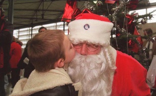 Photo d'illustration montrant un enfant en train d'embrasser un père Noël.