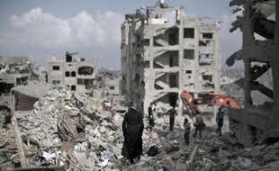 Une femme palestinienne marche au milieu de ruines près de Gaza City, le 6 août 2014