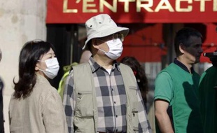 Des touristes asiatiques portent un masque, pour se protéger du virus de la grippe A (H1N1) dans le centre de Paris, mai 2009.