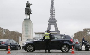 Un policier contrôle une voiture le 17 mars 2014 à Paris alors que la circulation alternée est de mise