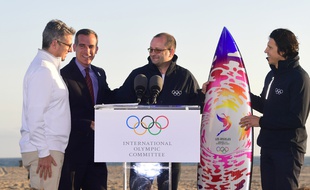 Le maire de Los Angeles, Eric Garcetti et Casey Wasserman, le président de LA2024 (à gauche) ont offert une planche de surf à Patrick Baumann (au centre) et Christophe Dubi (à droite) du Comité international olympique lors de leur visite en Californie le 11 mai 2017.