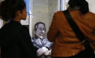 Des visiteurs du Palais de Tokyo regardent l'installation mettant en scène la marionnette de Nicolas Sarkozy, lors de l'édition 2012 de la Nuit blanche, à Paris.