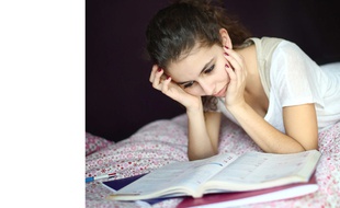 Une adolescente travaille chez elle