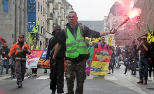 Un manifestant brandit un fumigène lors d'un défilé contre la loi Travail, ici le 14 juin à Rennes.