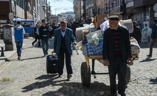 Des habitants rentrent chez eux après des heurts dans le quartier de Sur à Diyarbakir, en Turquie, le 13 mars 2016