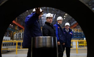 Le premier ministre Dimitri Medvedev (2e g) visite l'usine de tubes d'acier Seversky, premier fabricant russe de pipelines pour l'industrie pétrolière et gazière, le 14 octobre 2014 dans la ville de Polevskoï, dans les Ourals