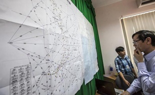 Un officiel vietnamien regarde une carte avec les détails des recherches en cours pour retrouver le Boeing 777, sur l'île de Pho Quoc le 11 mars 2014