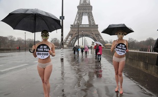Deux membres de l'association Peta manifestent contre l'utilisation de peaux animales pour se vêtir près de la Tour Eiffel à Paris le 6 mars 2017.