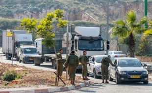 Des soldats israéliens fouillent des véhicules à l'entrée de la colonie d'Ariel, en Cisjordanie, le 24 décembre 2015