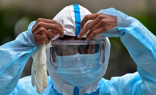 Un spécialiste se prépare à traiter un bâtiment contre le coronavirus à Kuala Lumpur, en Malaisie.