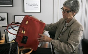 Dominique Chombert expertise un sac dans les locaux d'Instant Luxe, le 30 juillet 2014 à Paris