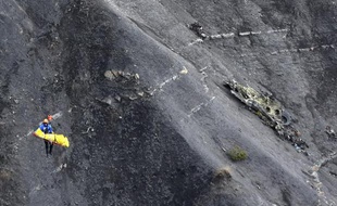 Un enquêteur hélitreuillé le 26 mars 2015 par la gendarmerie passe au-dessus de débris de l'A320 qui s'est abîmé à Seyne-Les-Alpes, dans les Alpes-de-Haute-Provence