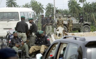 An armoured vehicle with soldiers and police patrol guard members of Bayelsa StateHouse of Assemby patrol in Yenagoa 29 November 2005. Members of Bayelsa House of Assembly held a sitting to deliberate on the impeachment notice served on the state governor Diepreye Alamieyeseigha that escaped from London where he was standing trial for money laundering. AFP PHOTO/PIUS UTOMI EKPEI