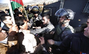 Un policier israélien attrape par le coup Ziad Abu Ein lors d'une manifestation dans les environs de Ramallah le 10 décembre 2014