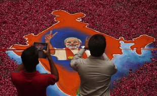 Des Indiens photographient le portrait de Modi, vainqueur des législatives, le 16 mai 2014.