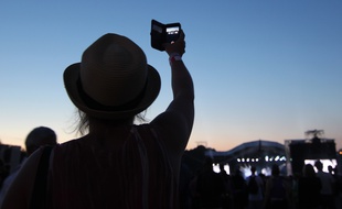 Une jeune femme filme avec son smartphone, ici lors d'un festival à Carhaix.