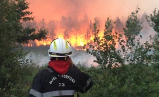 Un pompier observe l'incendie survenu à Saint-Jean d'Illac (Gironde), le 24 juillet 2015.