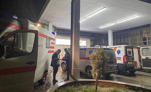 Des ambulances devant l'hôpital de la ville de Peja où sont les victimes de l'attaque d'un bus scolaire au Kosovo, le 26 novembre 2021.