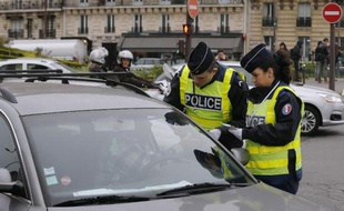 Des policiers contrôlent des véhicules alors que la circulation alternée est mise en place à Paris le 17 mars 2014