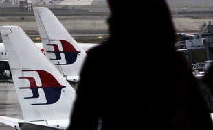 Une femme regarde des appareils de la Malaysia Airlines, le 26 mars 2014 à Kuala Lumpur.