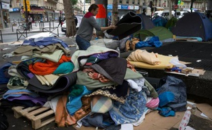 Des bénévoles récupèrent les tentes en bon état lors de l'évacuation d'un campement de migrants le 16 juin 2016 à Paris