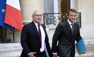 Le ministre des Finances Michel Sapin (à g) et le nouveau ministre de l'Economie Emmanuel Macron quittent le Palais de l'Elysée le 27 août 2014