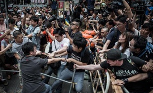 Des manifestants prodémocratie (d) tentent de protéger leur barricade de protestataires adverses (g) dans le quartier de Mong Kok à Hong Kong, le 4 octobre 2014
