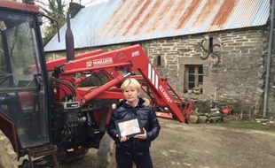 Marie Le Guelvou avec une photo de son frère devant la ferme familiale.