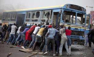 Des manifestants tentent de retourner un bus dans les rues de Dakar (Sénégal), le 1er février 2011.