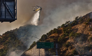 Un hélicoptère lutte contre le Getty Fire, un incendie qui s'est propagé le long de l'autoroute 405, à Los Angeles, le 28 octobre 2019.