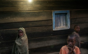 Des enfants devant une maison éclairée par l'électricité à Bugara, le 17 juillet 2016