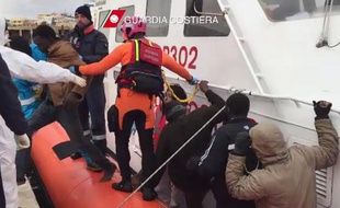 Des migrants descendent d'un bateau des garde-côtes italien après une opération de sauvetage au large de Lampedusa, le 10 février 2015