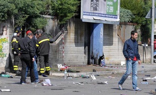 Des policiers italiens inspectent le site de l'explosion d'une bombe devant un lycée à Brindisi, sud de l'Italie, le 19 mai 2012.