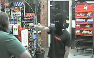 Capture d'écran d'une vidéo de surveillance montrant un apprenti braqueur tenter sa chance dans une épicerie...