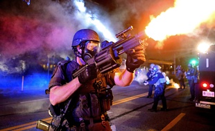 Un policier tire une grenade lacrymogène lors des émeutes des Ferguson, dans le Misouri, le 18 août 2014.