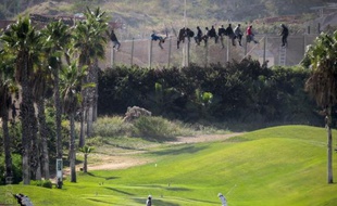 Des migrants sur la barrière de sécurité de l'enclave espagnole de Melilla le 22 octobre 2014