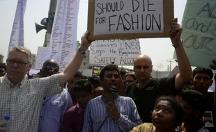 Des hommes dénoncent l'industrie textile lors de la manifestation organisée le 24 avril 2014 pour le premier anniversaire de l'effondrement de l'usine Rana Plaza au Bangladesh
