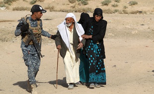 Des familles originaires du village de Bajwaniyah, à 30 km de Mossoul, ont fui la zone de combat, aidées par les membres des forces de sécurités, le 18 octobre 2016
