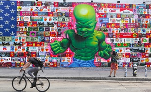 Man cycles past huge colorful mural on Houston Street NYC