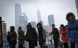 Des citadins sortent d'une station de métro de Pékin pour se plonger dans le brouillard de la capitale, un masque sur le visage, le 21 février 2017.