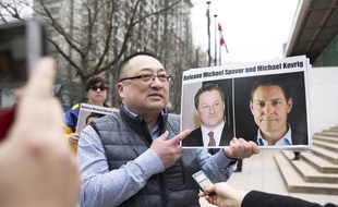 Les photos de Michael Kovrig et Michael Spavor brandies par un manifestant à Vancouver en mars 2019.