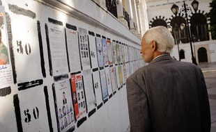 Un Tunisien devant les affiches des candidats aux élections de l'Assemblée constituante, à Tunis, le 20 octobre 2011.