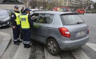 Paris, le 17 mars 2014. Des policiers contrôlent les véhicules alors que la circulation alternée est mise en place.
