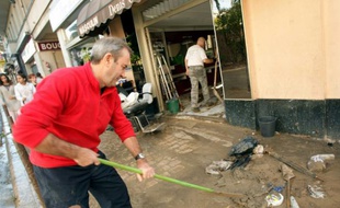 Des habitants nettoient les boutiques et trottoirs à Cannes après les inondations, le 4 octobre 20105 dans le sud-est de la France