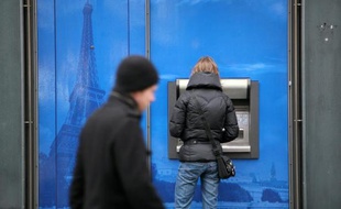 Une femme retire de l'argent dans un distributeur à Paris